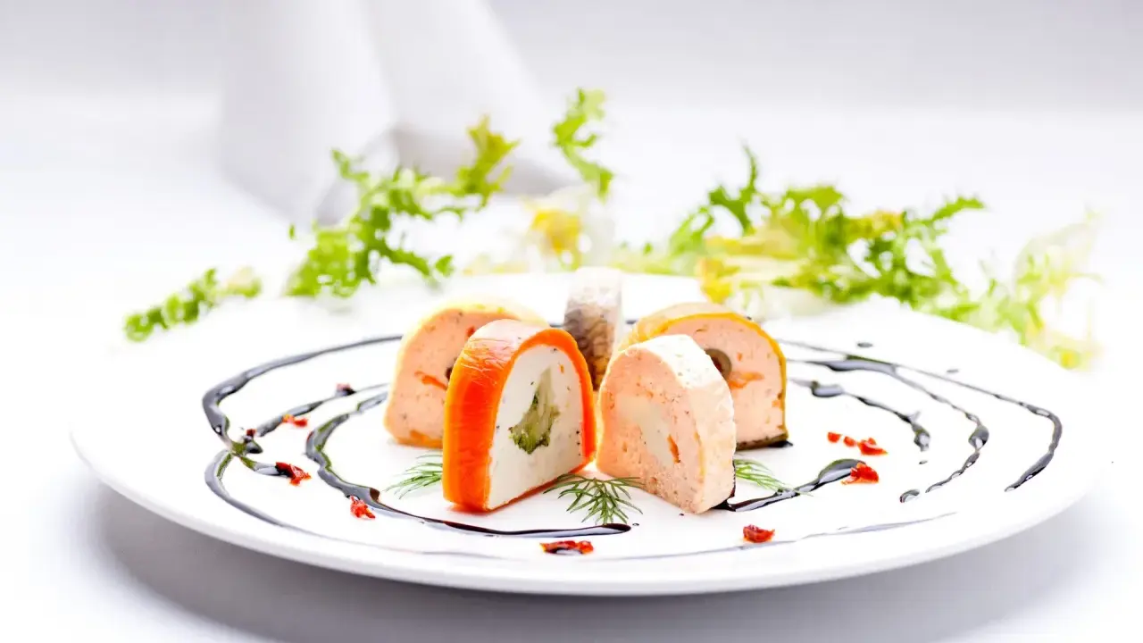 Eleganckie rolady rybne z warzywami, ozdobione sosem balsamicznym. Idealne na menu weselne z godzinami.