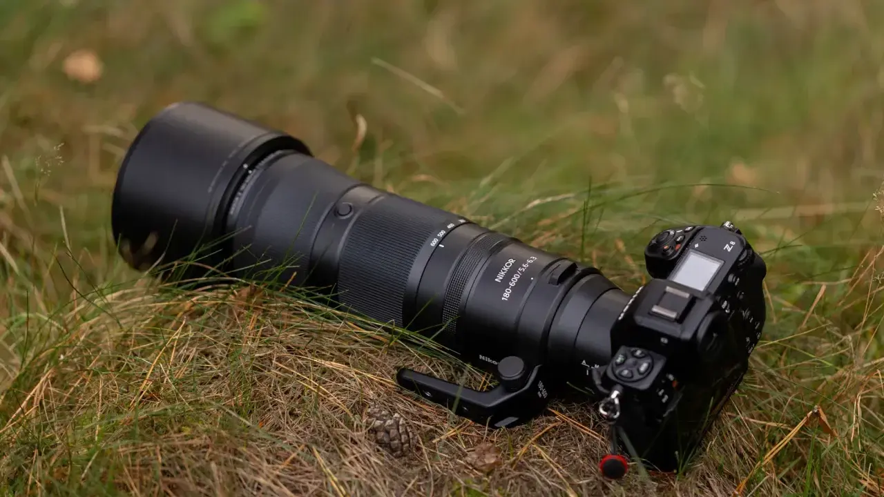 Profesjonalny aparat Nikon Z8 z obiektywem Nikkor 180-600mm leży na trawie. To co to jest aparat, to narzędzie do uwieczniania chwil.
