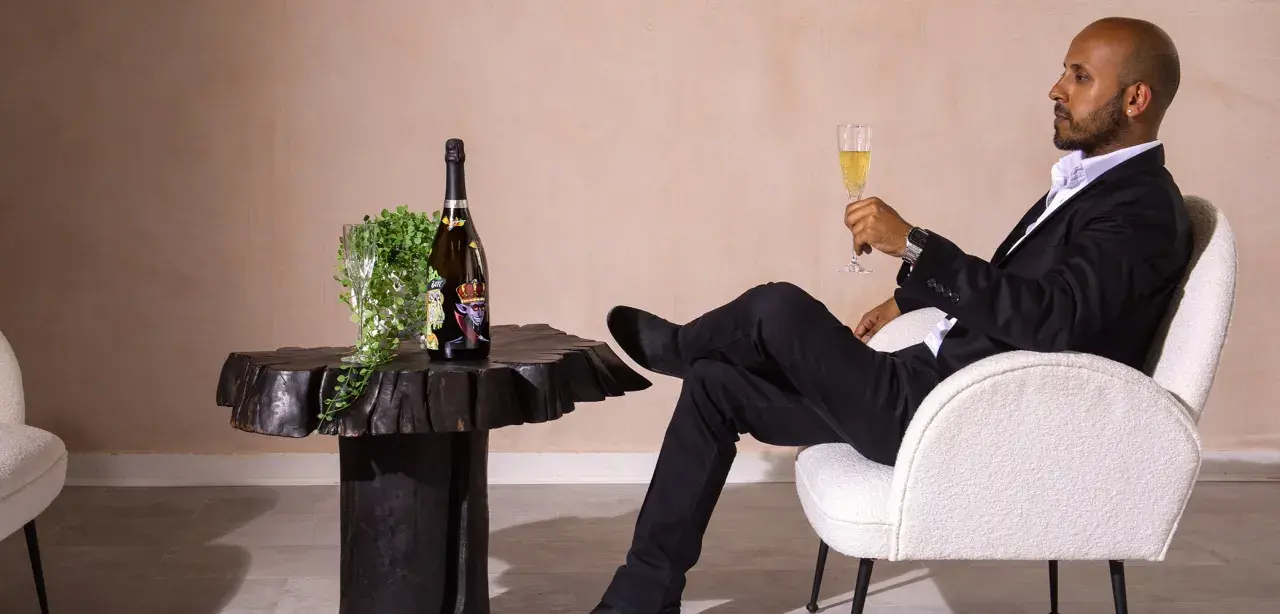 Ein Mann im Anzug genießt Champagner. Die aufwendige Herstellung erklärt, warum ist Champagner so teuer.