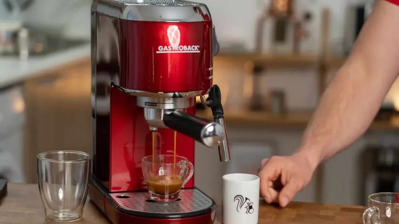 Rote Kaffeemaschine brüht Espresso mit Crema. Eine normale Kaffeemaschine für den perfekten Start in den Tag.