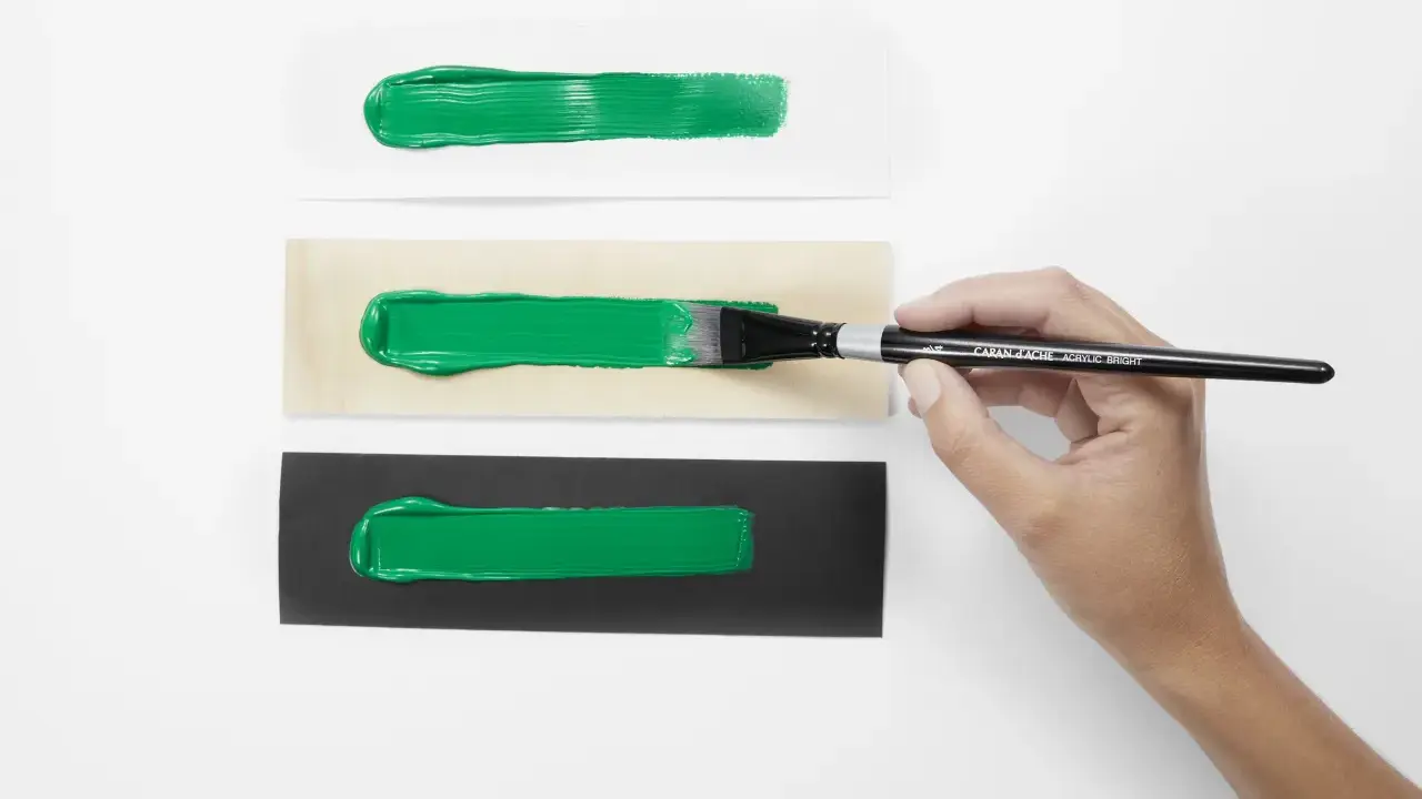 Grüne Acrylfarben-Streifen auf weißem, Holz- und schwarzem Untergrund. Perfekt für den Modellbau, um die Deckkraft zu testen.