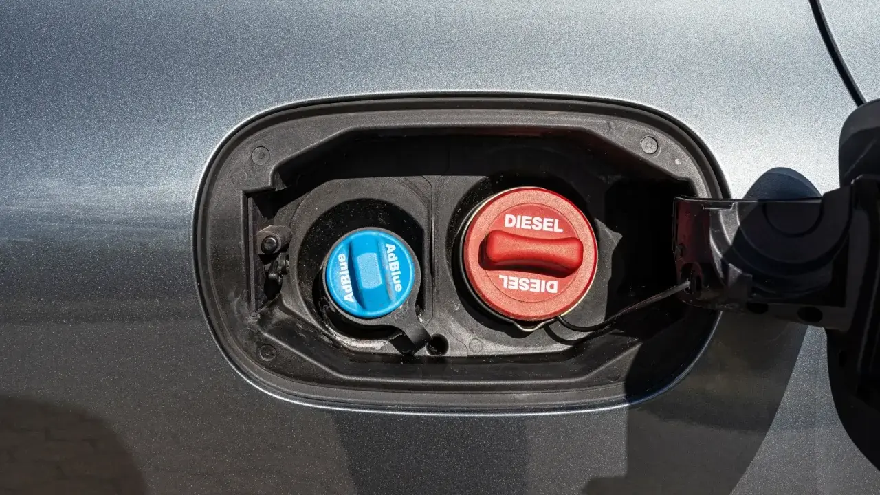 Dwa korki wlewu paliwa: czerwony z napisem DIESEL i niebieski z napisem AdBlue. AdBlue to płyn stosowany w nowoczesnych dieslach.