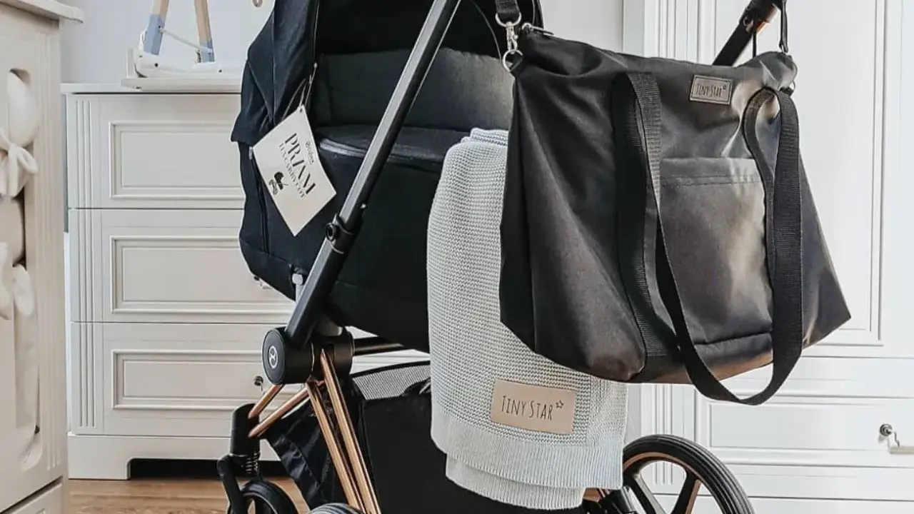 Stylowe wyposażenie wózka dla noworodka: czarna torba i miękki kocyk Tiny Star.