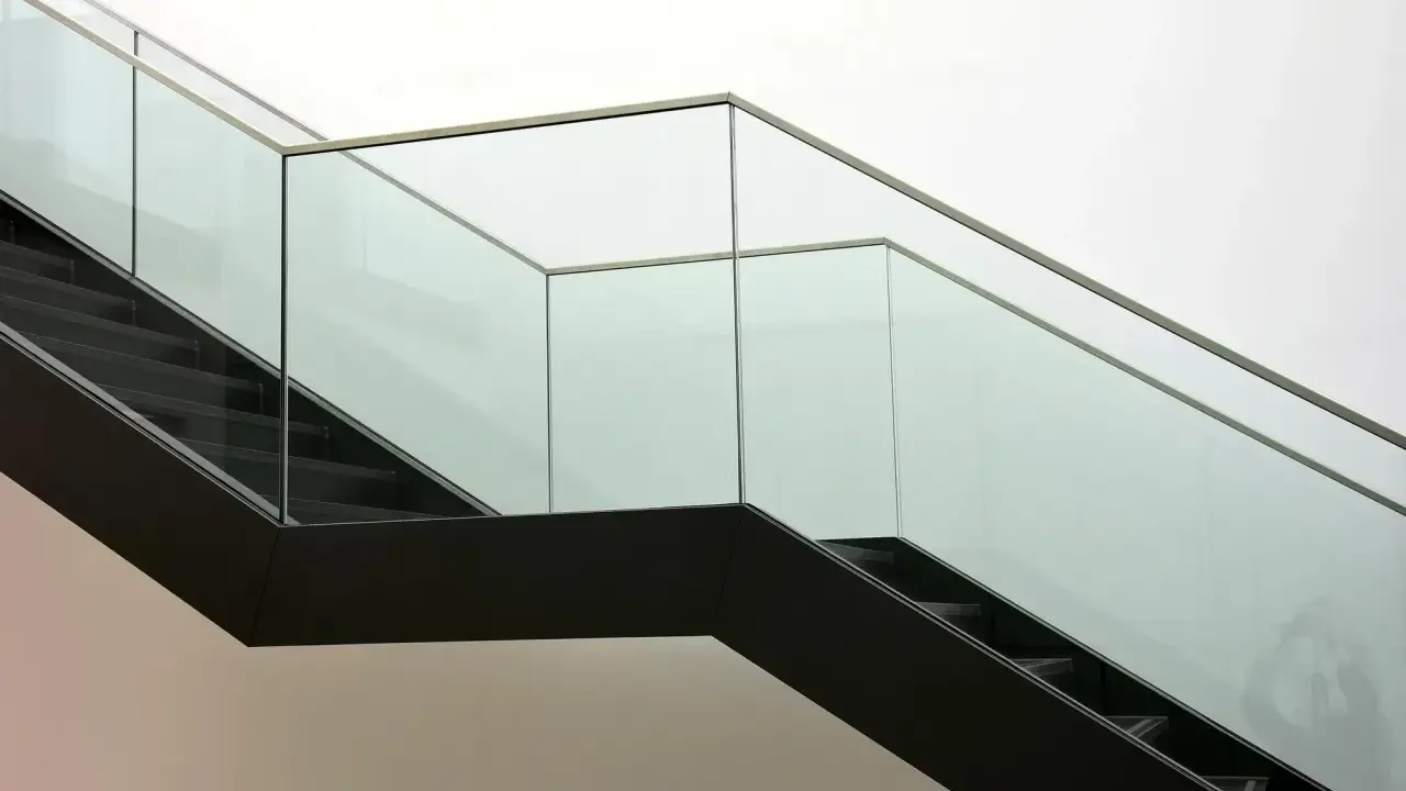 Escalera moderna con barandillas de cristal. ¿Cómo saber si un cristal es templado? La seguridad es clave.