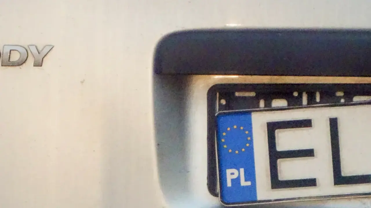 Widok na tył samochodu z widocznym fragmentem tablicy rejestracyjnej "EL". Litery "DY" na karoserii sugerują model pojazdu.