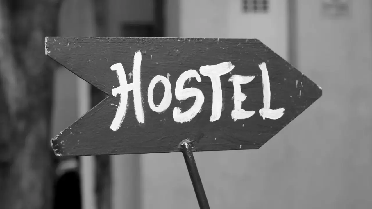 Piltavla med texten "Hostel" i vit färg, pekar åt höger. Enkel skylt som leder dig till ditt vandrarhem i Dalsland.