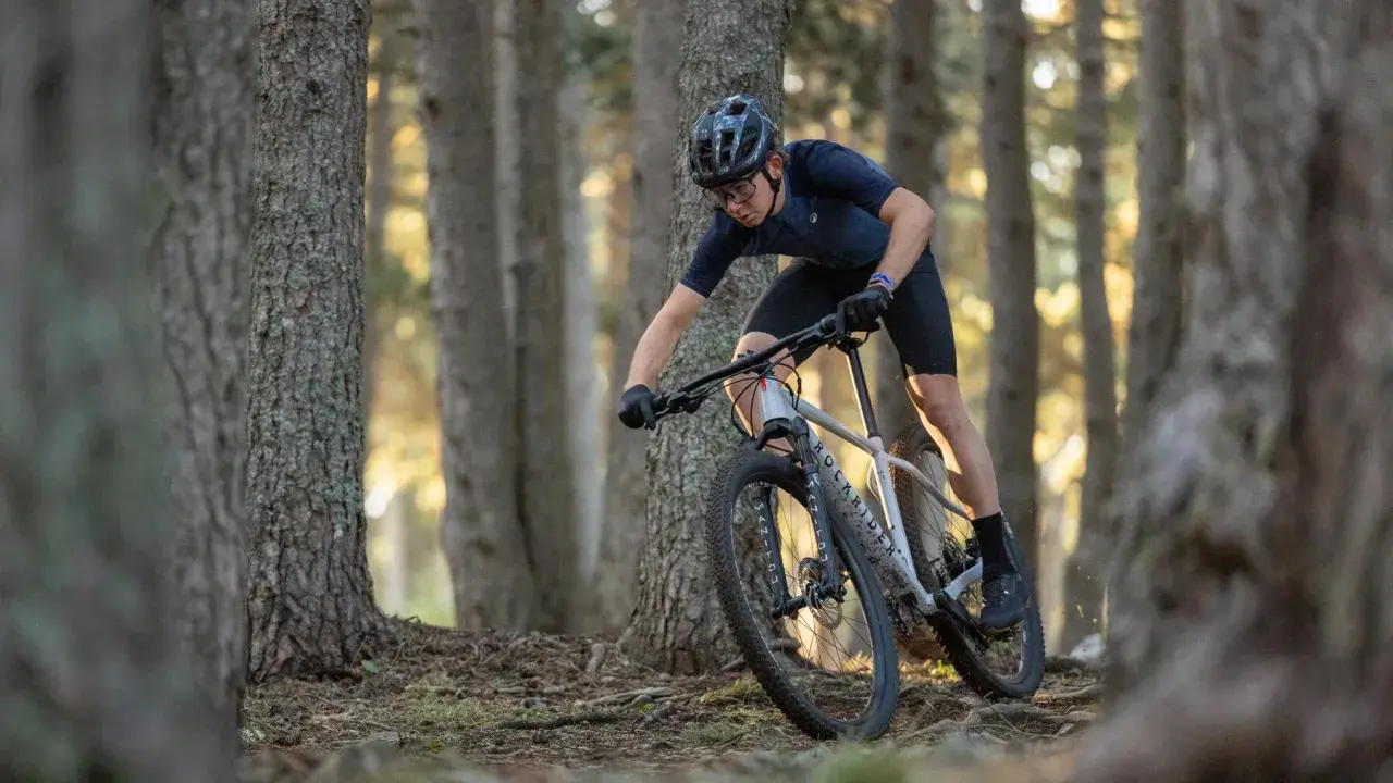 Kolarz na rowerze MTB zjeżdża leśną ścieżką. Czy to gravel czy mtb? Zdecydowanie mtb!
