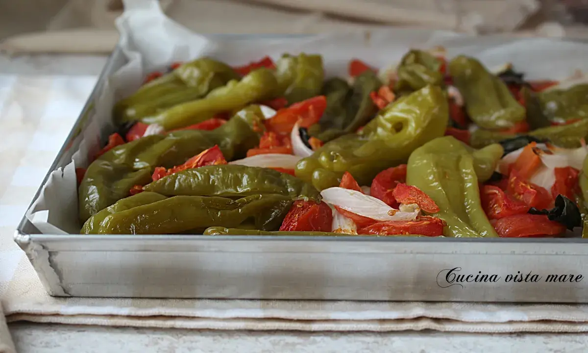 Friggitelli al forno con pomodoro e cipolla, un contorno saporito e colorato, pronto per essere gustato.