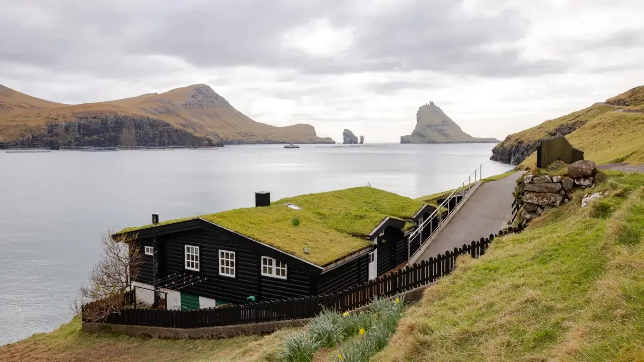Casa con tetto d'erba sulle isole Faroe, dove si trovano paesaggi mozzafiato e natura selvaggia.
