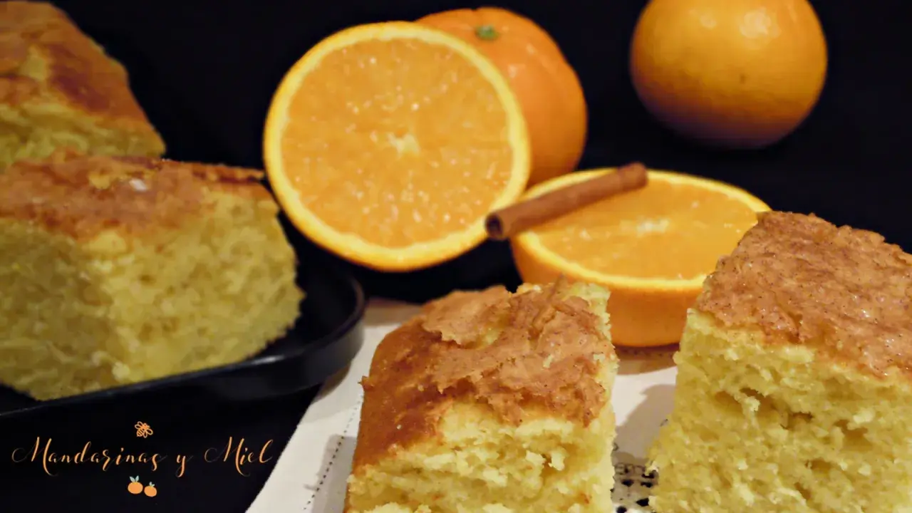 Deliciosa coca de naranja esponjosa, con naranjas frescas y una rama de canela. ¡Perfecta para disfrutar!