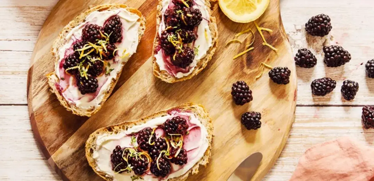 Tartines de pain grillé avec fromage frais, mûres et zeste de citron. Un encas healthy et gourmand, parfait pour un petit-déjeuner ou une pause.