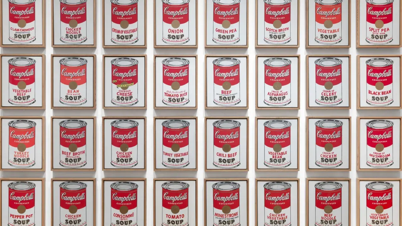 Andy Warhol's repetition art showcases a grid of Campbell's soup cans, each a unique flavor, creating a vibrant pop art statement.