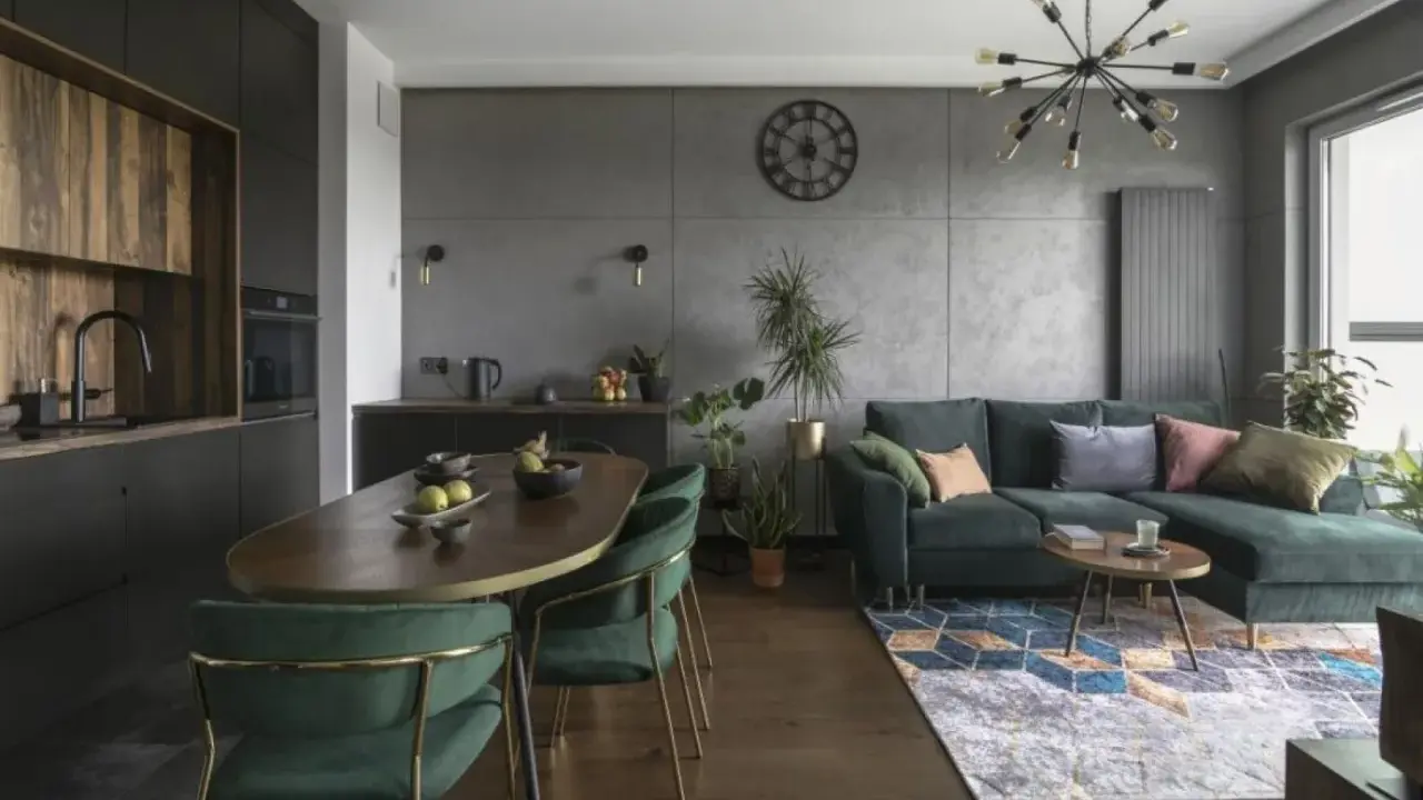 Nowoczesny czarny salon z drewnem, zielona kanapa, owalny stół i designerska lampa.
