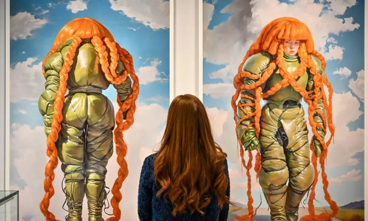 A woman admires two surreal paintings of figures in puffy green suits with bright orange braided hair at Christie's NYC.