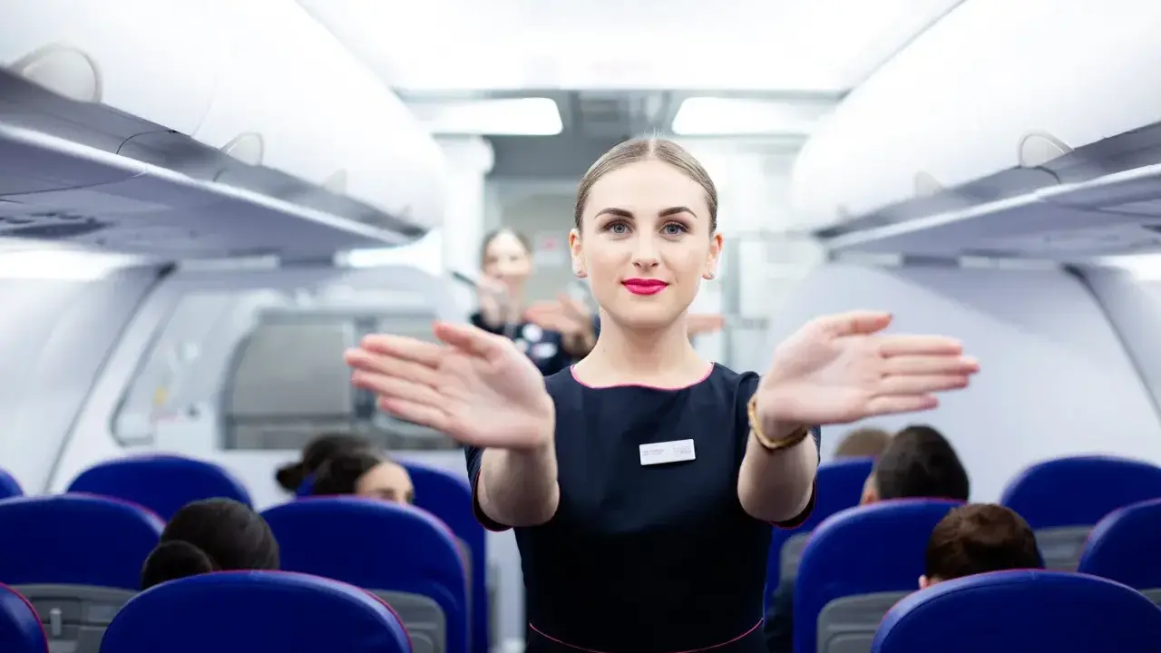 Uśmiechnięta stewardessa Wizzair wita pasażerów. Czy trzeba drukować kartę pokładową Wizzair? Sprawdź przed podróżą!