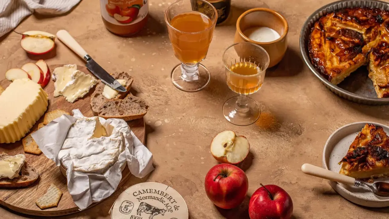 Un plateau gourmand avec camembert, pain, beurre, pommes et tarte aux pommes, une spécialité normandie.