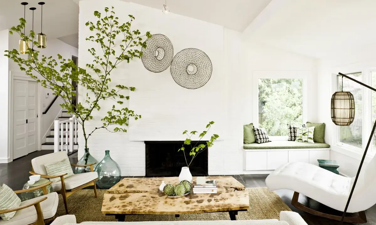 Ideas para decorar ramas secas: una rama verde decora el salón moderno con chimenea, mesa de madera y sillones.