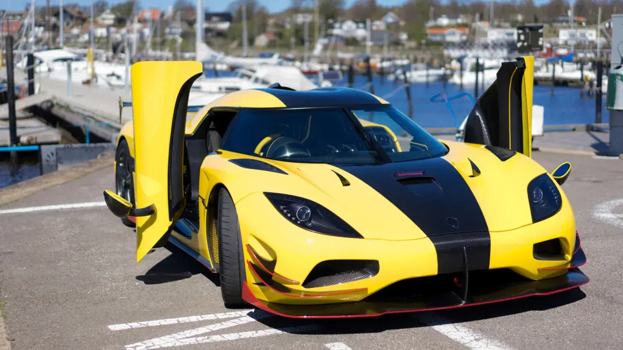 Gelber Koenigsegg Agera RS mit geöffneten Türen am Hafen, bereit für eine Spritztour.