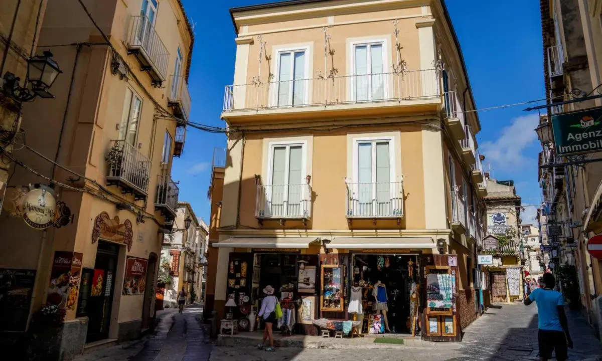 Un vicolo di Tropea con negozietti e palazzi color ocra, un'atmosfera che ricorda la porta vaticana.