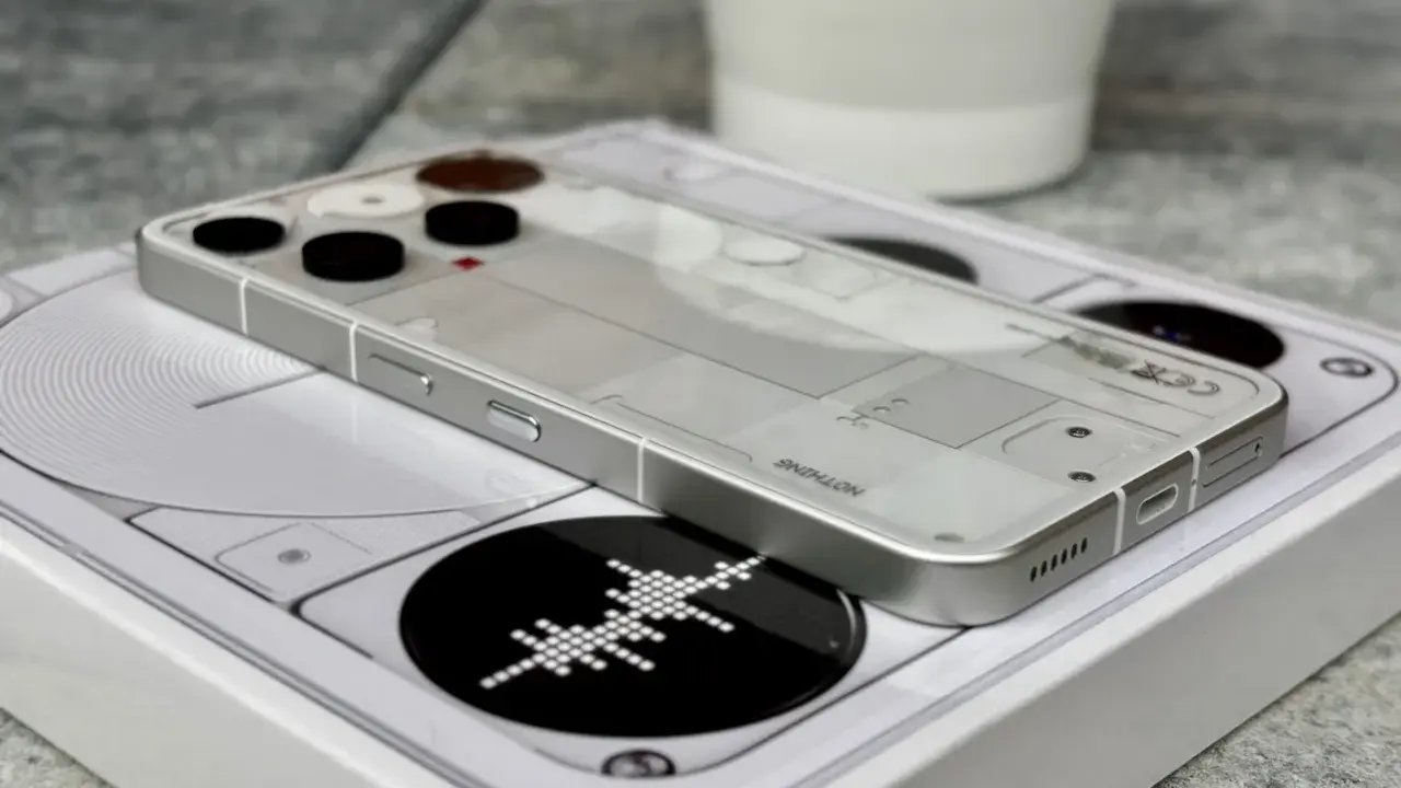 Przezroczysty telefon survivalowy z minimalistycznym designem, leżący na białym pudełku z grafiką.