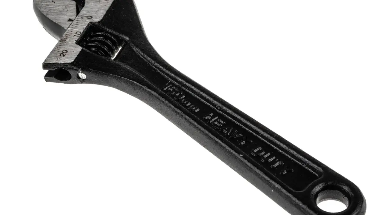 Llave inglesa negra, con marcas de medición en milímetros y la inscripción "HEAVY DUTY". Es una herramienta robusta, como el pie del rey.