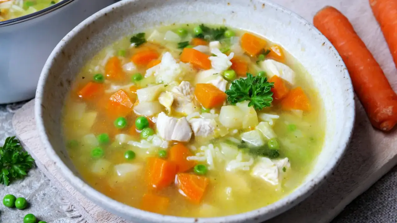 Herzhafte Hühnersuppe mit Reis, Karotten und Erbsen. Ein ideales Gericht für kalte Tage, das zu den besten Suppen Rezepten zählt.