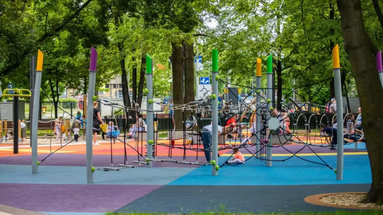 Kolorowy plac zabaw w Bielsku z linami do wspinaczki i huśtawkami. Wspaniałe atrakcje dla dzieci w słoneczny dzień.