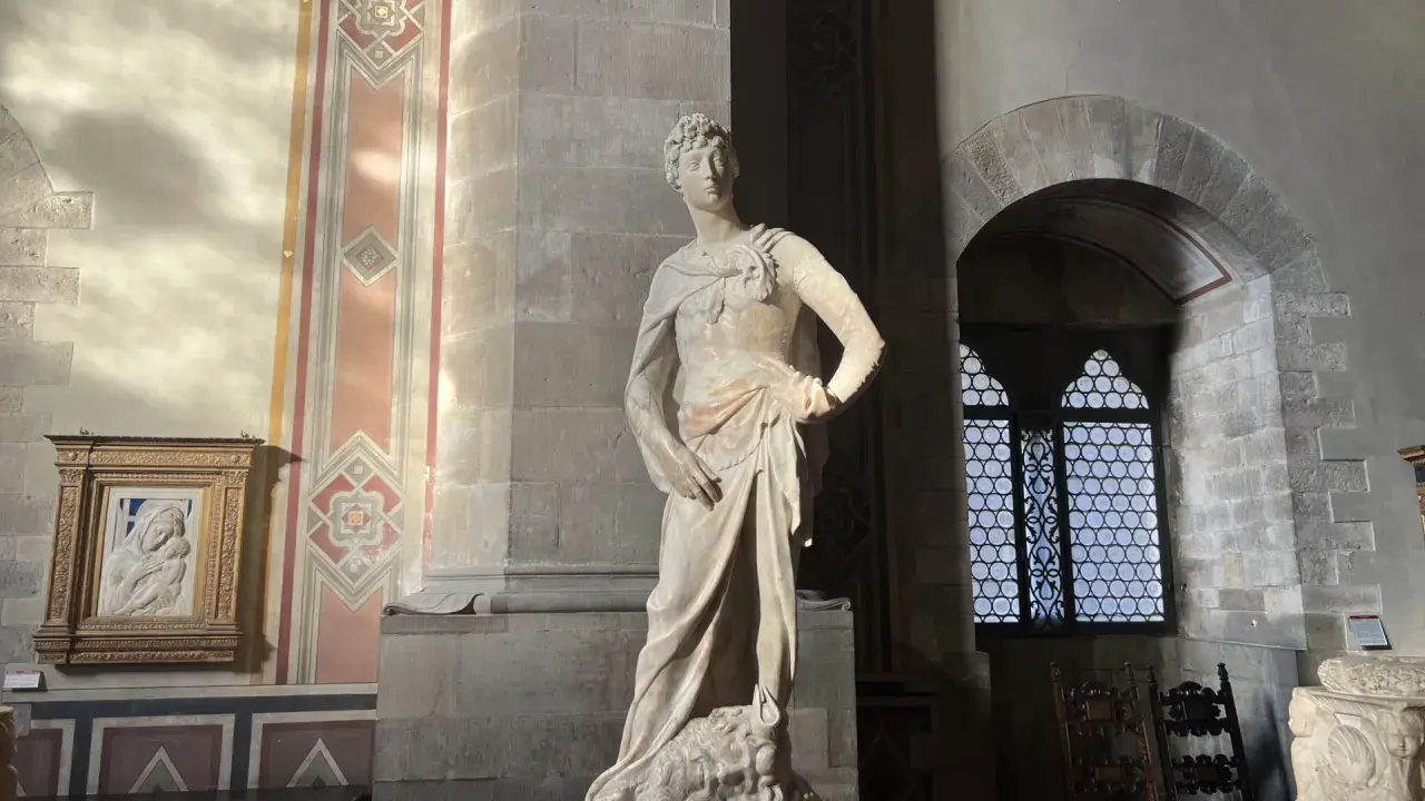 Statue de David par David Verrocchio, debout sur la tête de Goliath, dans un musée.