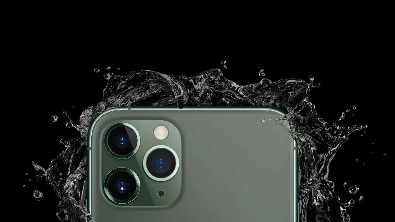 El iPhone 11, con sus cámaras de 12 megapíxeles, resiste salpicaduras de agua en un fondo negro.