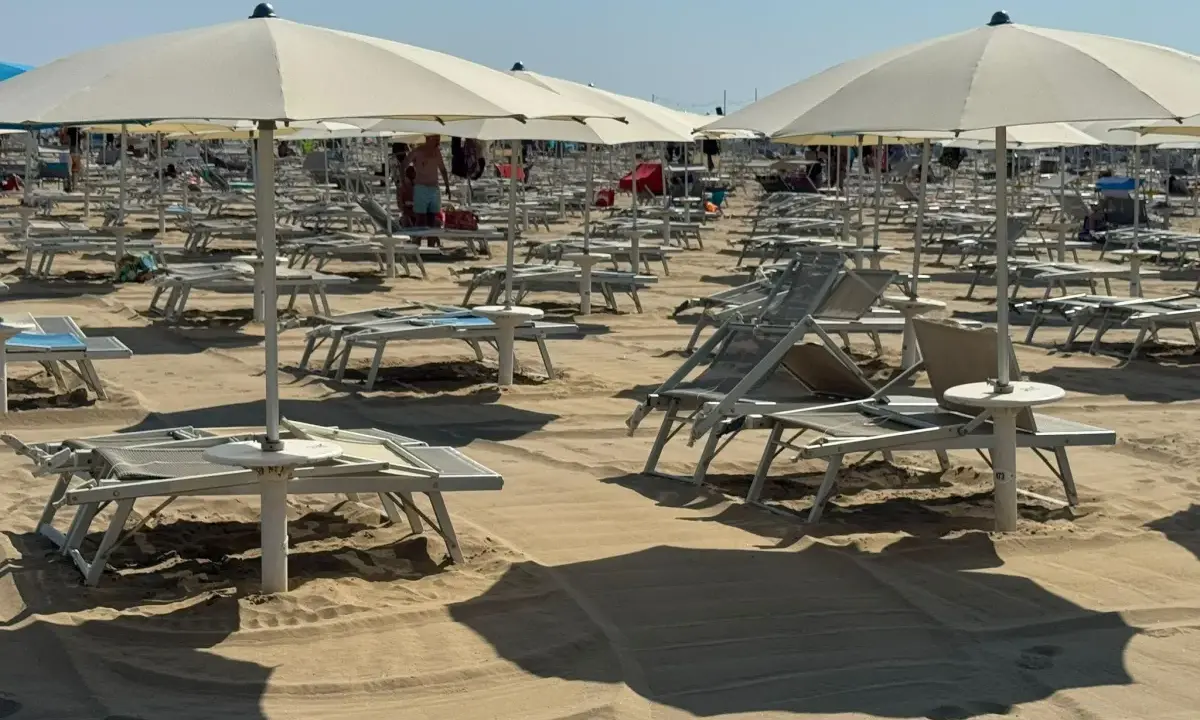 Ombrelloni e lettini pronti per il Ferragosto sulla Riviera Romagnola. La sabbia dorata attende i bagnanti.
