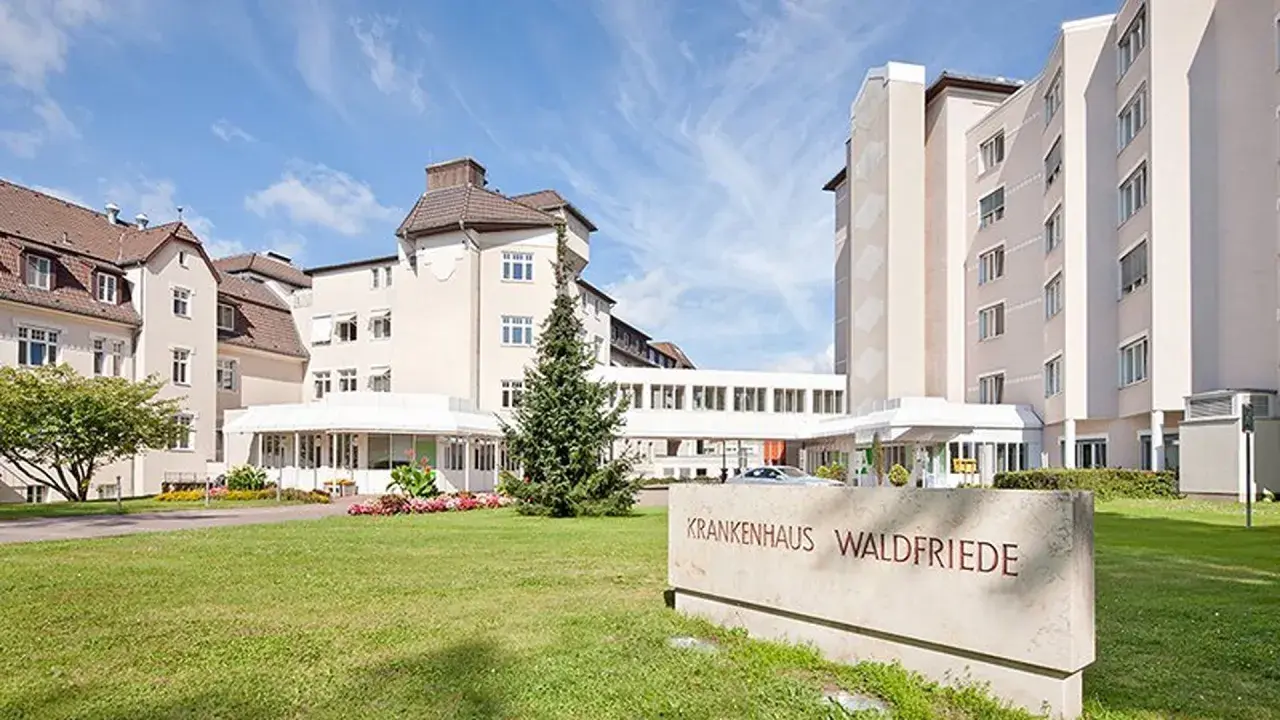 Il Krankenhaus Waldfriede, protagonista de "Le sorelle di Waldfriede volume 3", si presenta con un'architettura moderna e un'area verde curata.