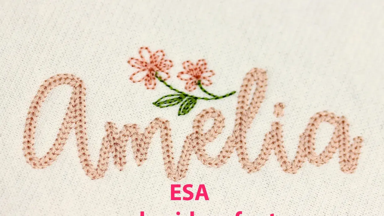 Różowa, haftowana czcionka "Amelia" z dwoma kwiatkami, idealna do tworzenia unikalnych projektów.