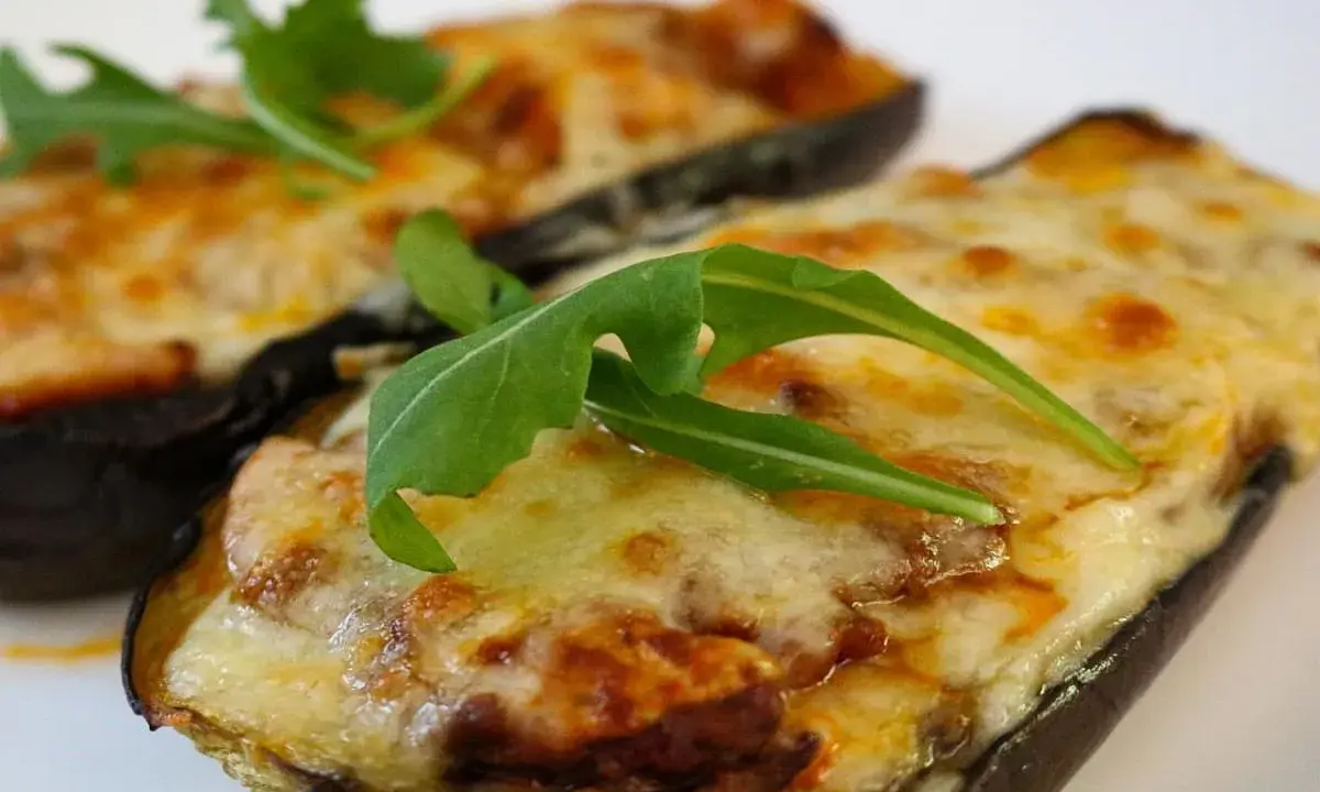 Melanzane ripiene al forno, un sapore autentico di mangiare calabrese, guarnite con rucola fresca.