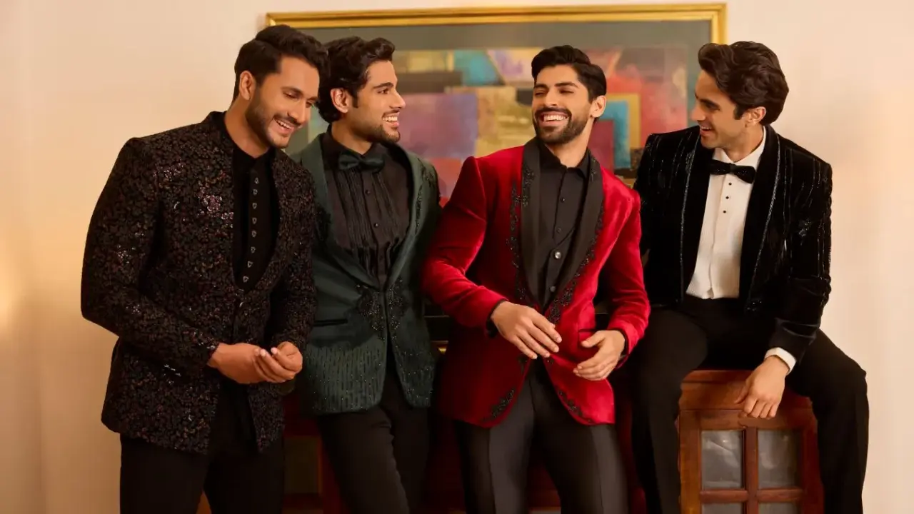 Four men in stylish winter wedding attire, showcasing embellished jackets in black, green, red, and velvet.