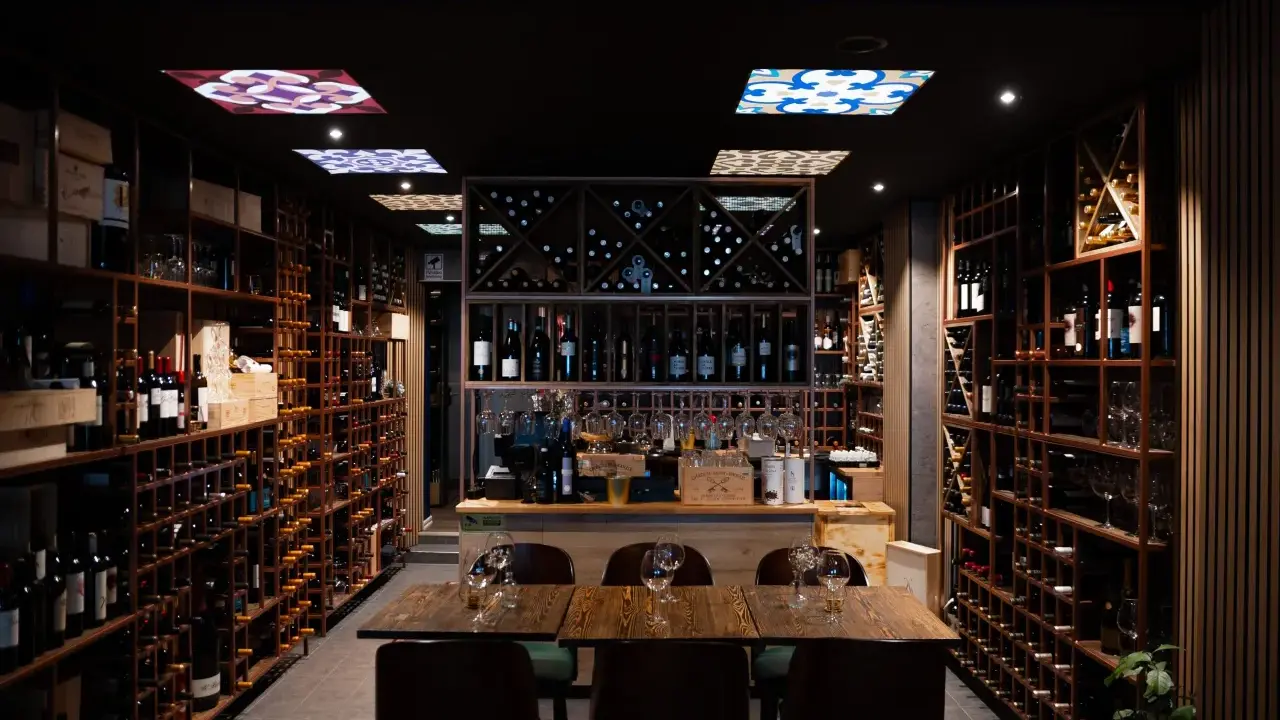 En vinbar med hyllor fyllda med flaskor, redo för en kväll med pasion tapas och goda viner.