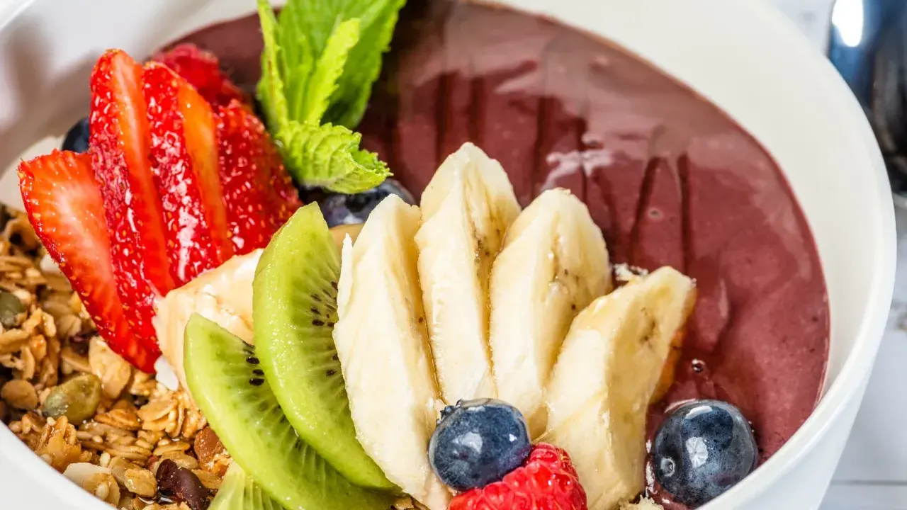 Acai-Bowl mit Erdbeeren, Bananen, Kiwi, Blaubeeren, Himbeeren und Granola. Was ist Acai? Eine gesunde Beere für dein Frühstück!