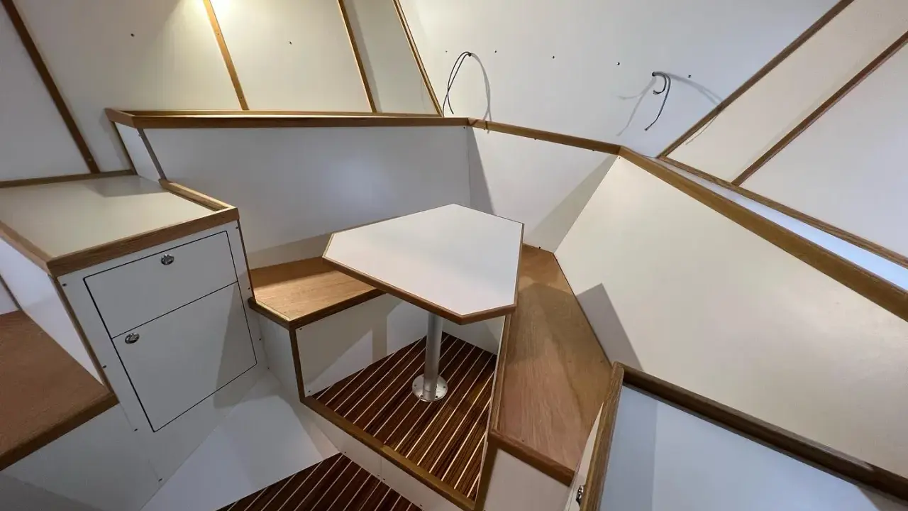 Modern båt inredning inspiration med vit och trädetaljer. En unik bordlösning och smarta förvaringsutrymmen.