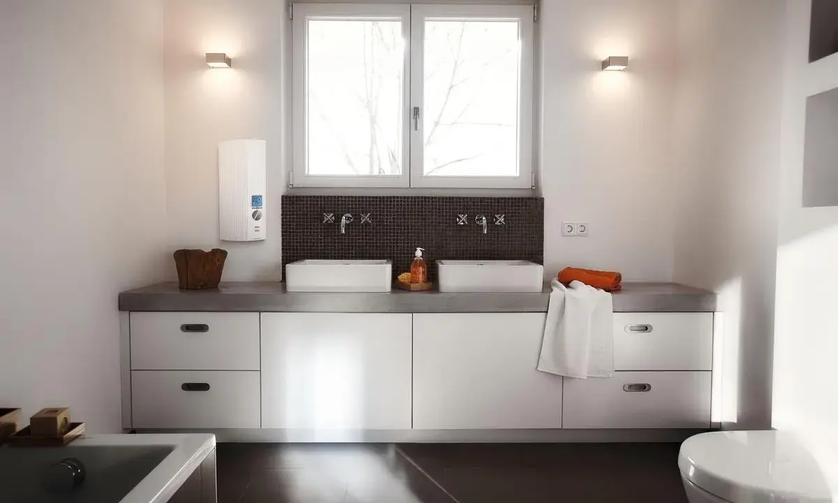 Modernes Badezimmer mit Doppelwaschbecken und einem AEG Durchlauferhitzer 24 kW an der Wand.