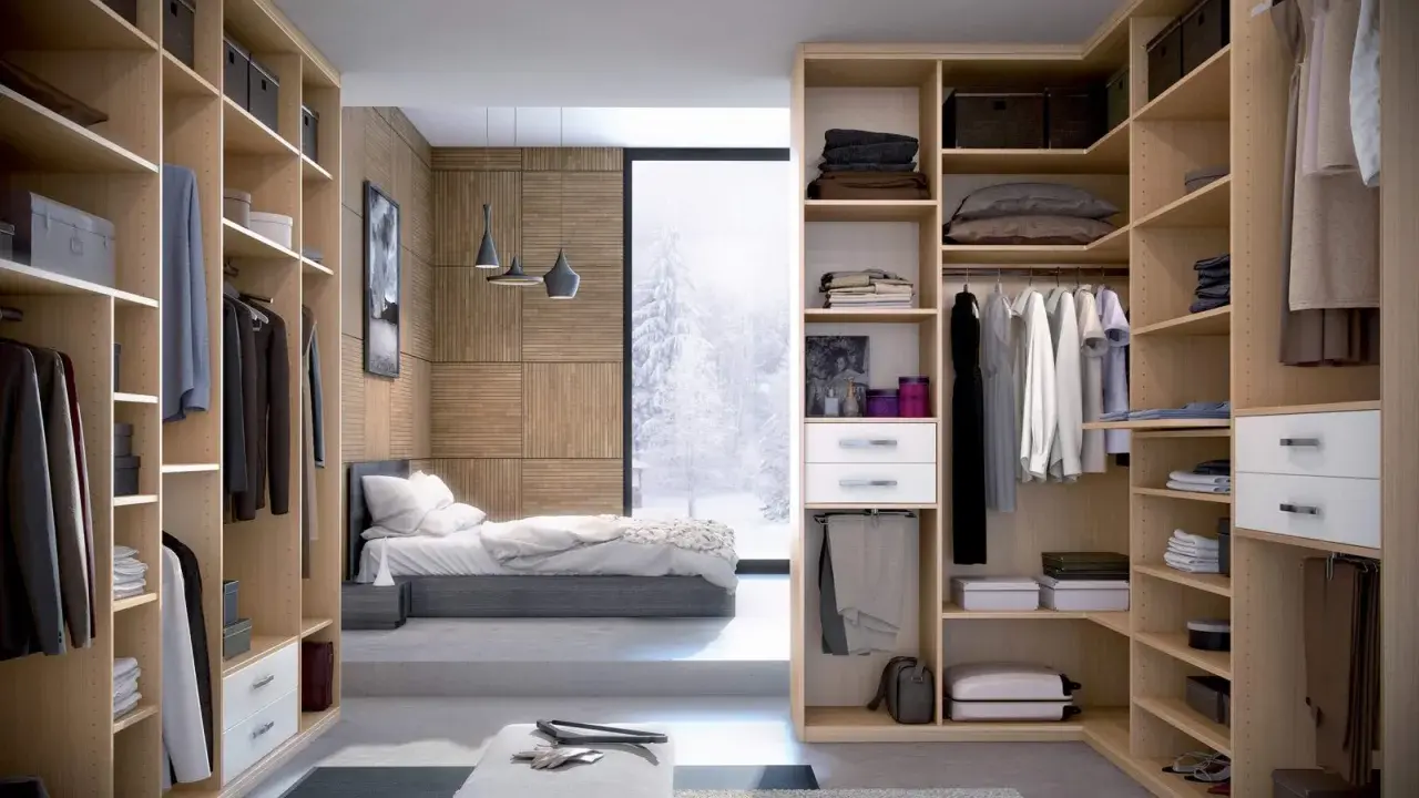 Une idée dressing chambre : un espace organisé avec des étagères en bois clair, des vêtements suspendus et pliés, et une vue sur un paysage enneigé.