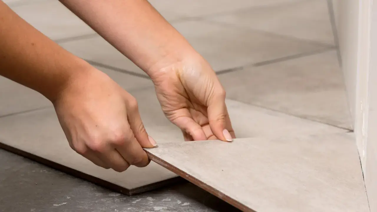 Manos colocando una baldosa de porcelánico para cortar a medida.