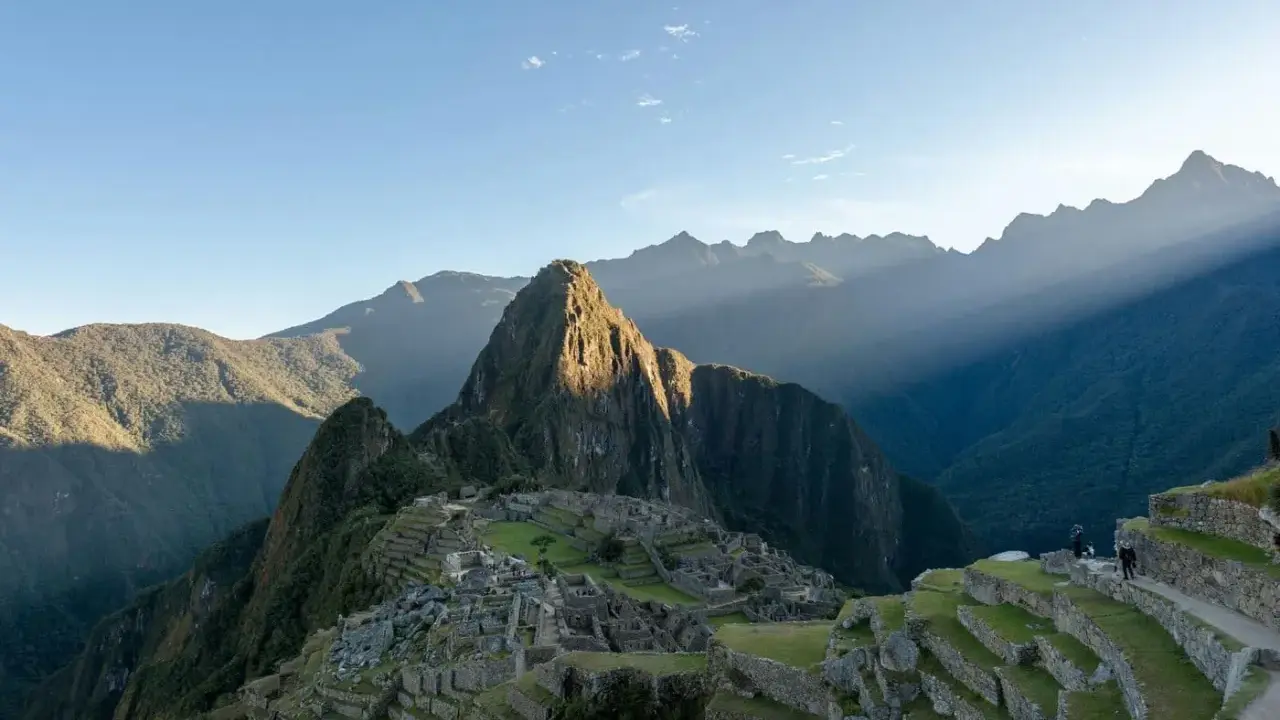 Machu Picchu i Peru, med solstrålar som bryter igenom molnen. En resa hit kan kräva vaccination Peru.