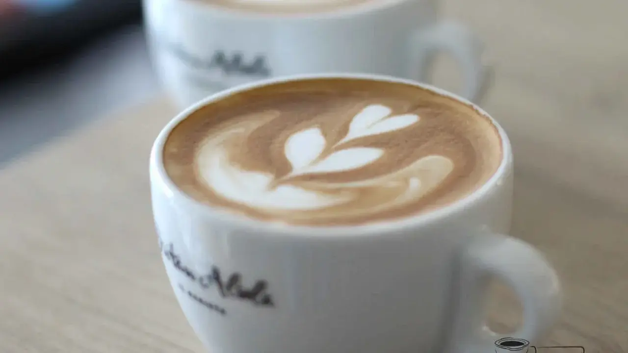 Zwei Tassen mit Latte Art, ein Herzmuster auf dem cremigen Schaum. Der perfekte Cappuccino für einen gemütlichen Morgen.
