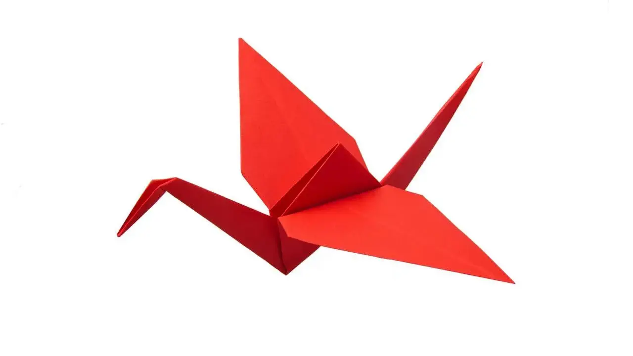 Ein roter Papierkranich, kunstvoll gefaltet als Origami.