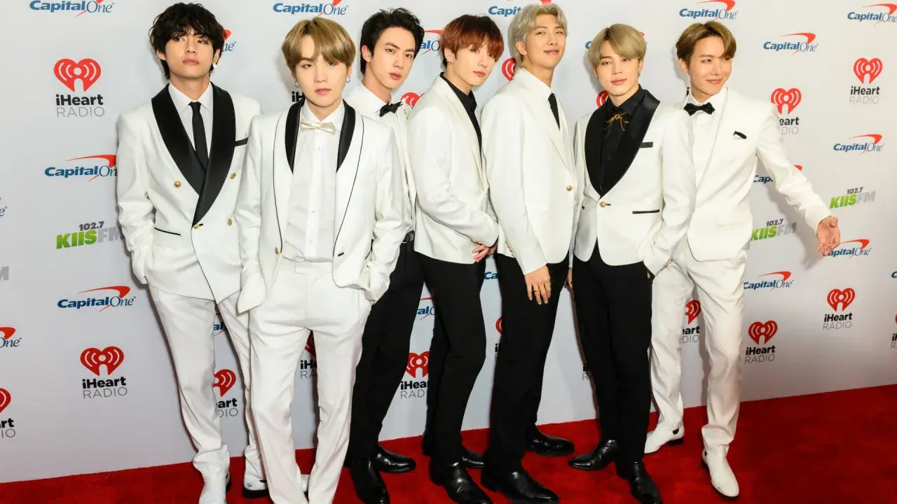 Siedmiu członków BTS w białych garniturach na czerwonym dywanie. Zastanawiasz się, ile kosztuje bilet na koncert BTS?