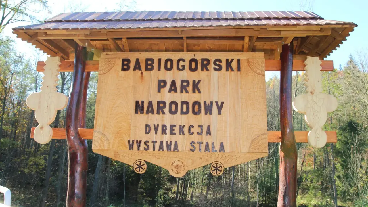 Drewniana brama z napisem "Babiogórski Park Narodowy" zaprasza do odkrywania **zawoja atrakcje**.