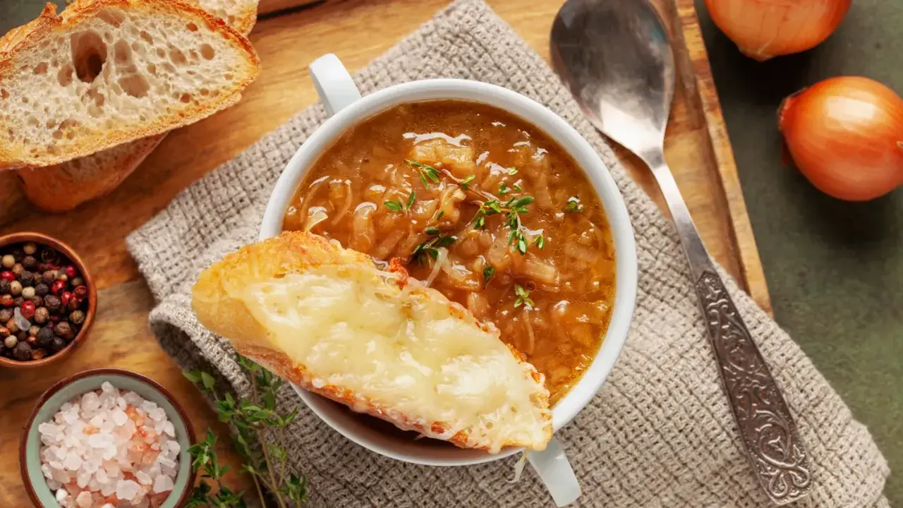 Une délicieuse recette de soupe à l'oignon, gratinée avec du fromage fondant sur une tranche de pain croustillant.