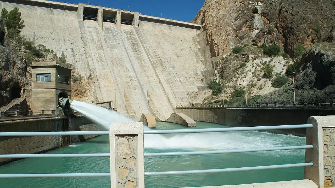 El embalse del Cenajo libera agua a través de un gran conducto, creando una cascada espumosa en el río.