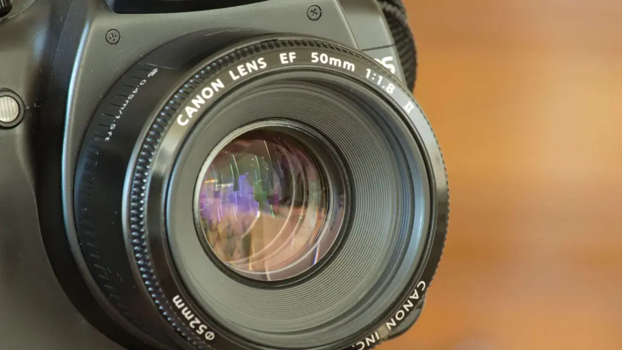 La fotocamera sfocata dopo caduta mostra un obiettivo Canon EF 50mm 1:1.8.