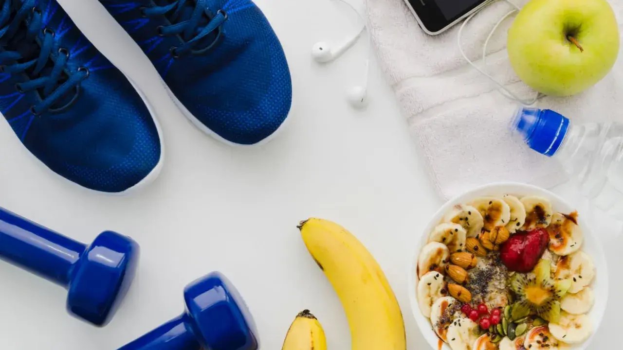 Gesunde Ernährung vor dem Halbmarathon: Haferflocken mit Früchten, Bananen, Apfel, Wasser und Sportutensilien.