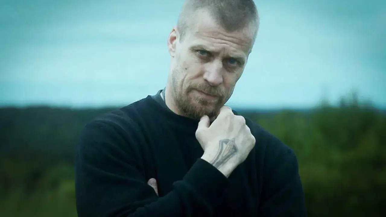 Jens Hultén, känd från filmer och tv-program, med en intensiv blick och en tatuering på handen.